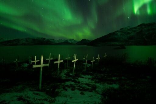 A cemetery illuminated by the northern lights in Kapisillit