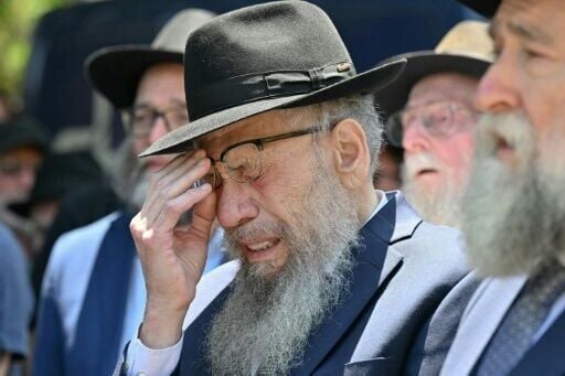 A mourner weeps as he follows the hearse carrying the coffin of rabbi Eli Schlanger, who was killed in the December 14 Bondi beach shooting.
