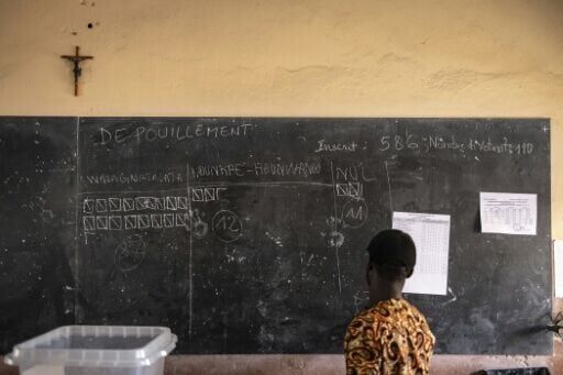 An electoral official views early results during counting at a polling station in Porto-Novo
