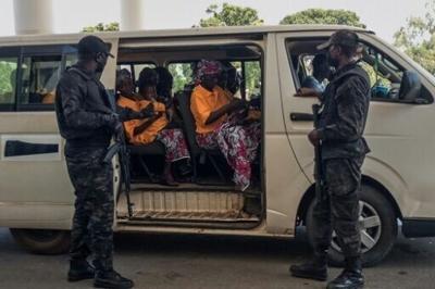 Security officers stand guard next to a bus carrying freed worshippers in northern Nigeria