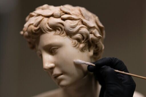 A conservator cleans the sculpture "Apolo" by Italian artist Silvio Cosini at the Prado museum on October 23, 2025