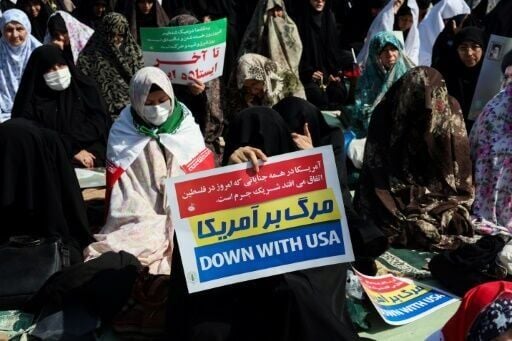 A woman holds an anti-US placard during Friday noon prayers in Tehran