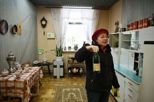 A museum employee displays a bottle of Chernobyl mineral water from the 80s in a reconstruction of a typical Pripyat kitchen at the Museum of Slavutych and the Chernobyl Nuclear Power Plant in Slavutych