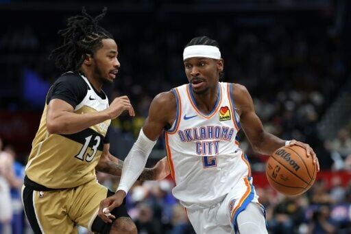 Shai Gilgeous-Alexander dribbles past Sharife Cooper on his way to 40 points in Oklahoma City's stormy win over Washington