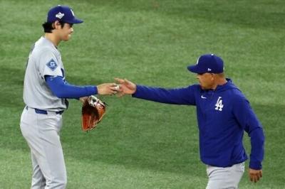 Los Angeles Dodgers manager Dave Roberts, at right taking the ball from Shohei Ohtani, says the Japanese batting and pitching star will not take the mound for defending champion Japan in March's World Baseball Classic