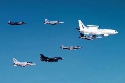 This handout image taken on July 23, 2024 and released by the Australian Defence Force shows a Royal Australian Air Force (RAAF) E-7A Wedgetail airborne early warning and control aircraft (top R) in formation flight with an RAAF EA-18G Growler electroni...
