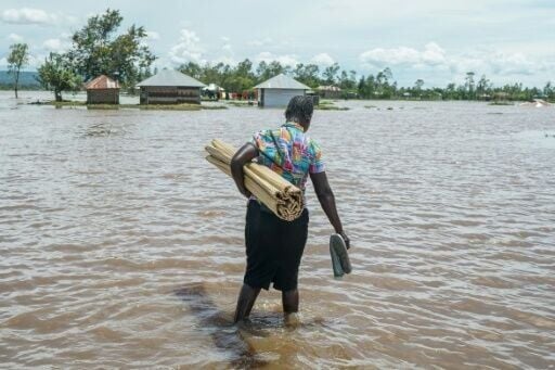 A woman in Kenya's Nyakach region wades through flooding triggered by torrential rain