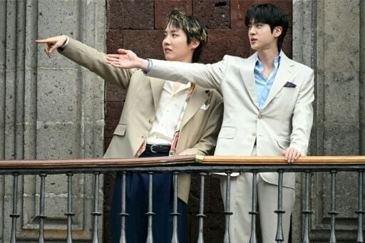 J-Hope (L) and Jin (R), from the South Korean K-pop band BTS, acknowledge fans from the balcony of the National Palace in Mexico City