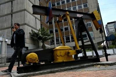 A man walks past a pumpjack outside the Bogota headquarters of Colombia's leading energy company Ecopetrol, which is planning pilot projects that activists say could harm the environment