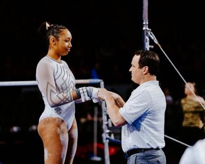 Mizzou gymnast Olivia Kelly stands with coach Shannon Welker before her bar routine