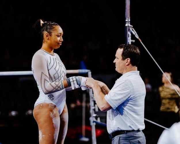 Mizzou gymnast Olivia Kelly stands with coach Shannon Welker before her bar routine