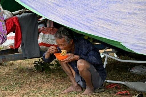 A man eats noodles under a shelter at a temporary camp in Cambodia's Oddar Meanchey province on December 11, 2025