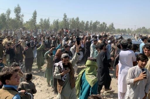 Afghans cheer on Taliban security personnel in Jalalabad, where officials said a Pakistani fighter jet crashed