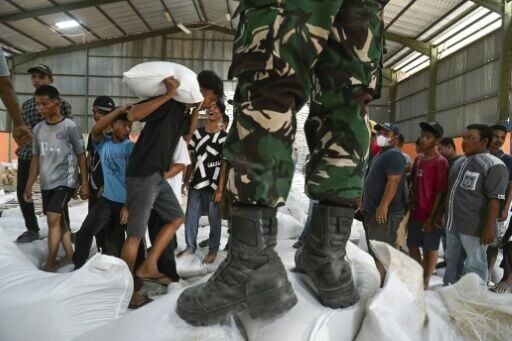 Soldiers oversaw the distribution of rice after reports of looting in Indonesia's flood-struck villages