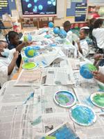 Kindergartners at Sophia P. Kingston use Selma Sun papers to make paper mache Earths