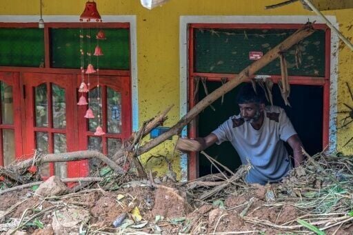 VK Muthukrishnan, 42, removes debris from his house following landslides in the aftermath of Cyclone Ditwah in Hadabima village near Sarasavigama on December 4, 2025