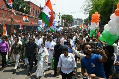 Chief Minister of West Bengal and Chairperson of All India Trinamool Congress, Mamata Banerjee, greets supporters as she arrives to file her nomination papers on April 8