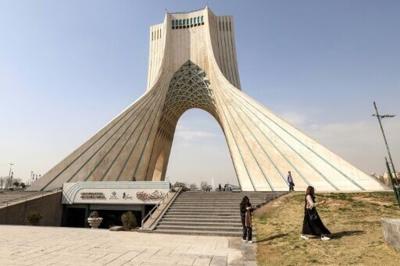 People walk near Tehran's landmark Azadi (Freedom) Tower in February before the United States and Israel launched a war a war against Iran