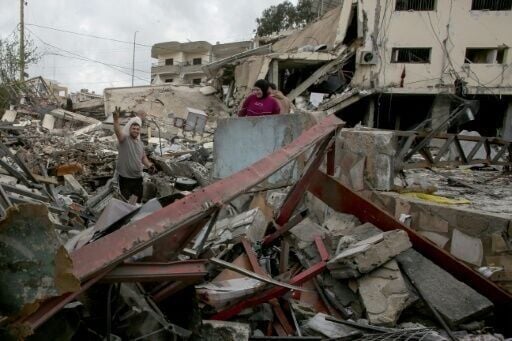 A man flashes the V for victory sign as he stands on the rubble of his destroyed house after returning to the southern Lebanese city of Nabatieh