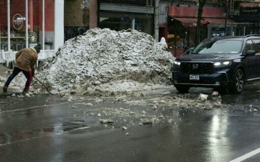 A man shovels a pile of snow from a recent storm ahead of a new winter wallop