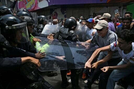 Opponents to the government of Venezuelan interim President Delcy Rodriguez clash with the police as they demonstrate in demand of salary and pension raises in Caracas on April 8, 2026