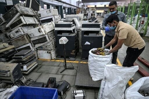 Workers weigh dismantled electronic parts at 'Ecowork', an e-waste recycling facility in Ghaziabad, India