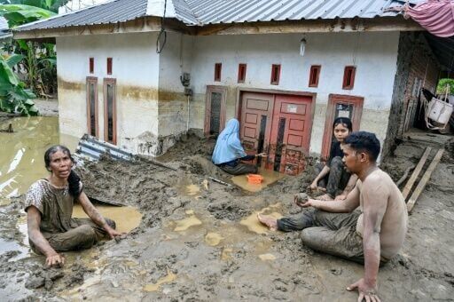 Dozens of people were killed in Indonesia's Aceh province, where residents cleared mud from flooded homes