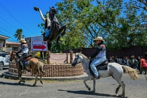Men ride horses along a street during the Rodeo Festival in the province of Masbate
