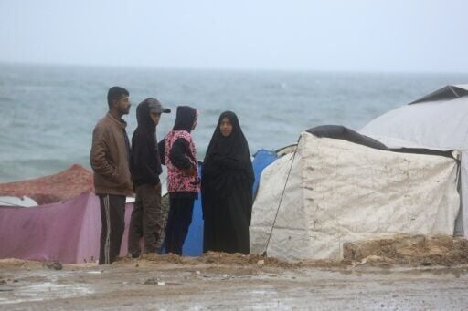 Displaced Palestinians stand next to tents west of Deir al-Balah in central Gaza. The UN resolution calls for the resumption of humanitarian aid deliveries, at scale