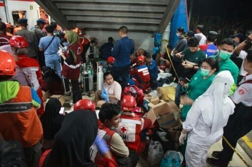 Medical staff and rescue workers prepare on a platform next to a train collision site after a passenger train locomotive pierced through the rear car of a commuter train at Bekasi Timur station on April 28, 2026