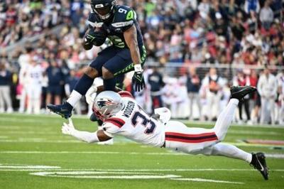 Seattle running back Kenneth Walker III hurdles New England Patriots safety Craig Woodson in the Seahawks' Super Bowl win over the Pats