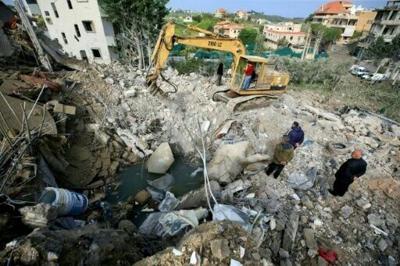 An excavator clears the rubble from the site of an overnight Israeli strike that targeted the southern Lebanese village of Kfar Hatta