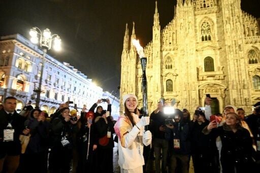 Italian ballet dancer Nicoletta Manni carries the Olympic flame in front of Milan's gothic Duomo ahead of Friday's opening ceremony