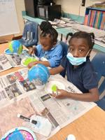 Kindergartners at Sophia P. Kingston use Selma Sun papers to make paper mache Earths