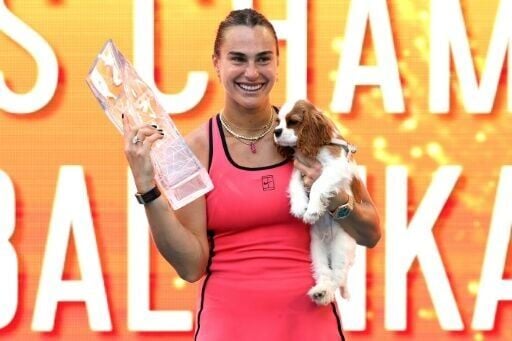 Aryna Sabalenka celebrates with the Butch Buchholz trophy and her dog Ash after beating Coco Gauff to win the Miam Open WTA 1000 title