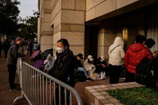 People wait in line outside the West Kowloon Law Courts building to hear verdicts in the trial of pro-democracy media tycoon Jimmy Lai
