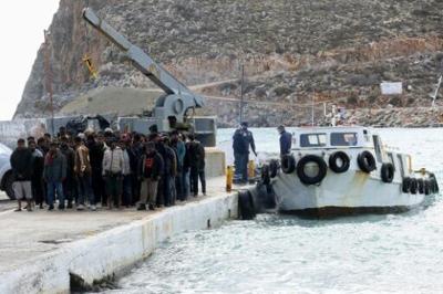 Migrants disembark from a boat at a port in Heraklion, southern Crete, on February 21