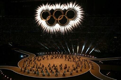The Olympic rings are revealed above dancers during the opening ceremony of the Winter Olympics in the San Siro stadium in Milan