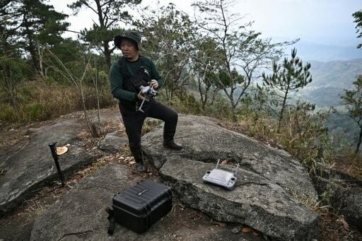 Hmong volunteer firefighter Mongkol Yingyotmongkolsaen using a drone to monitor fires in the Doi Suthep-Pui National Park area of Chiang Mai