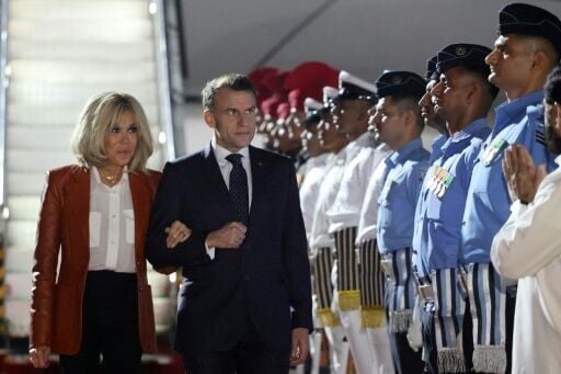 France's President French President Emmanuel Macron (C-R) and his wife Brigitte Macron (L) are welcomed by India's officials upon their arrival in Mumbai