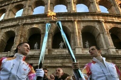Singer Achille Lauro (R) and producer and DJ Edoardo Manozzi (aka Boss Doms) pass the torch at the Colosseum in Rome on December 6