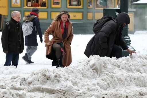 Pedestrians make their way through snow at an intersection in New York City at the tail end of a monster storm that pummeled the eastern half of the United States