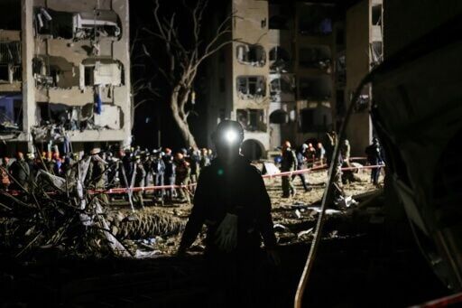 Rescuers at the site of an Iranian missile hit in southern Israel's Arad