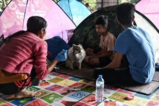 Displaced residents rest at an evacuation center in the Thai border province of Surin on December 11, 2025