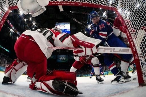 Denmark's Patrick Russell fights for the puck with Auston Matthews of Team USA during the Americans' win in the men's ice hockey pool game
