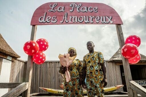 A couple poses at the 'Place des Amoureux' during a date ahead of Valentine's Day