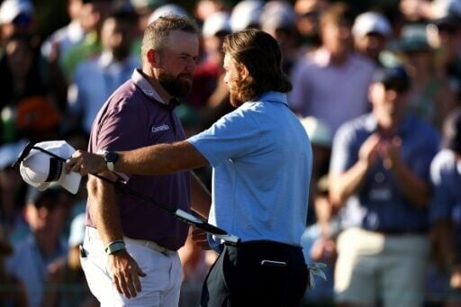 Shane Lowry of Ireland and Tommy Fleetwood of England share a hug after the third round of the Masters