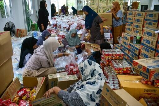 People prepare food aid packages for flood-affected residents in Thailand's southern province of Narathiwat
