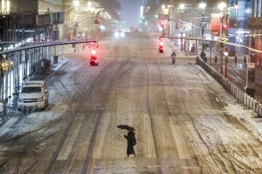 A woman crosses a snow-covered street in Manhattan near Grand Central Station