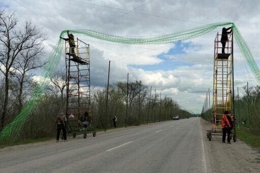 Ukrainian servicemen cover the road with a net to protect vehicles from drone attacks in the Zaporizhzhia region